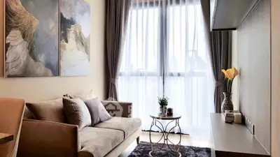 Elegant living room with modern furnishings, large windows allowing ample natural light, and tasteful art on the walls, creating a welcoming atmosphere.