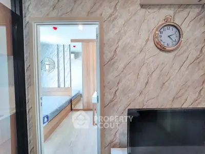 Modern interior with stylish clock and bedroom view, featuring elegant decor and sleek design.