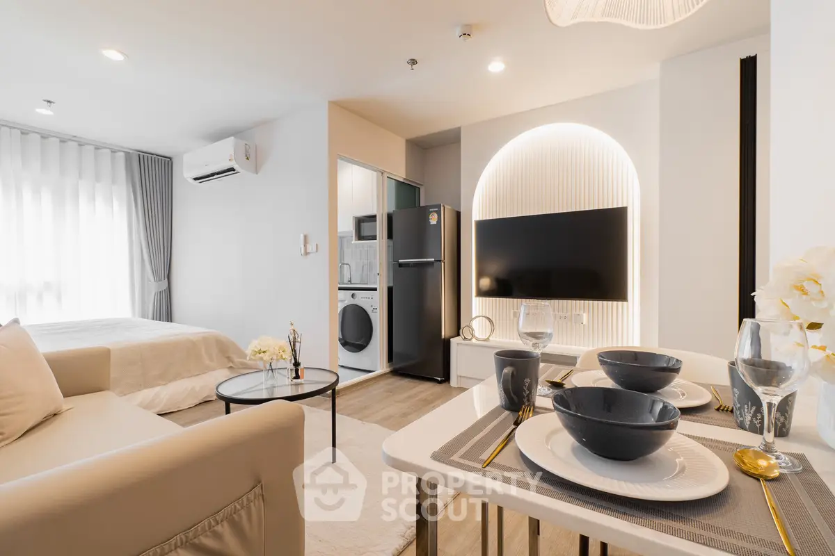 Modern studio apartment with open layout, featuring a cozy living area, dining space, and compact kitchen.