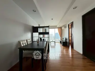Spacious modern living room with city view, wooden flooring, and elegant dining area.