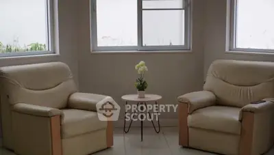 Cozy living room with two beige armchairs and a small round table.