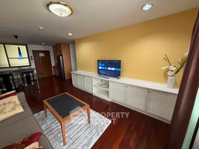 Spacious living room with modern decor and hardwood floors in a stylish apartment.