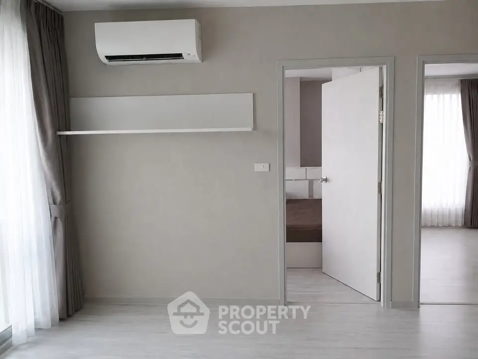Modern minimalist interior with air conditioning and open door to bedroom, featuring sleek design and natural light.