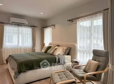 Elegant bedroom with modern decor, featuring a cozy bed, stylish armchair, and large windows for natural light.