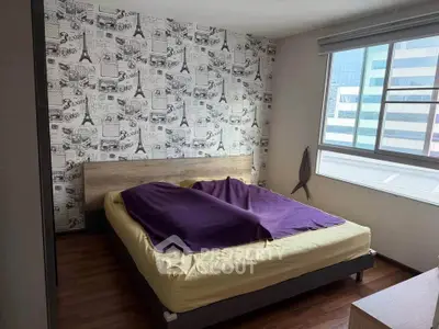 Modern bedroom with stylish wallpaper and large window offering city views.