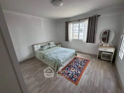 Spacious bedroom with modern decor and natural light, featuring a cozy bed and stylish vanity.