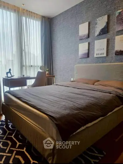 Modern bedroom with stylish decor and natural light, featuring a cozy bed and a functional study desk.