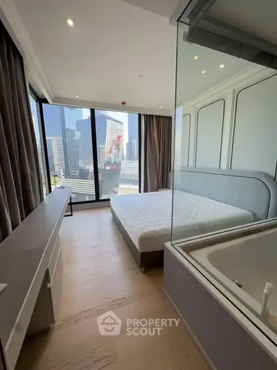 Modern bedroom with city view and glass-enclosed bathtub