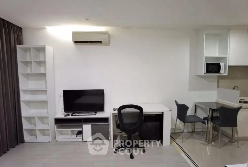 Modern living room with sleek furniture and integrated kitchen area, perfect for urban living.