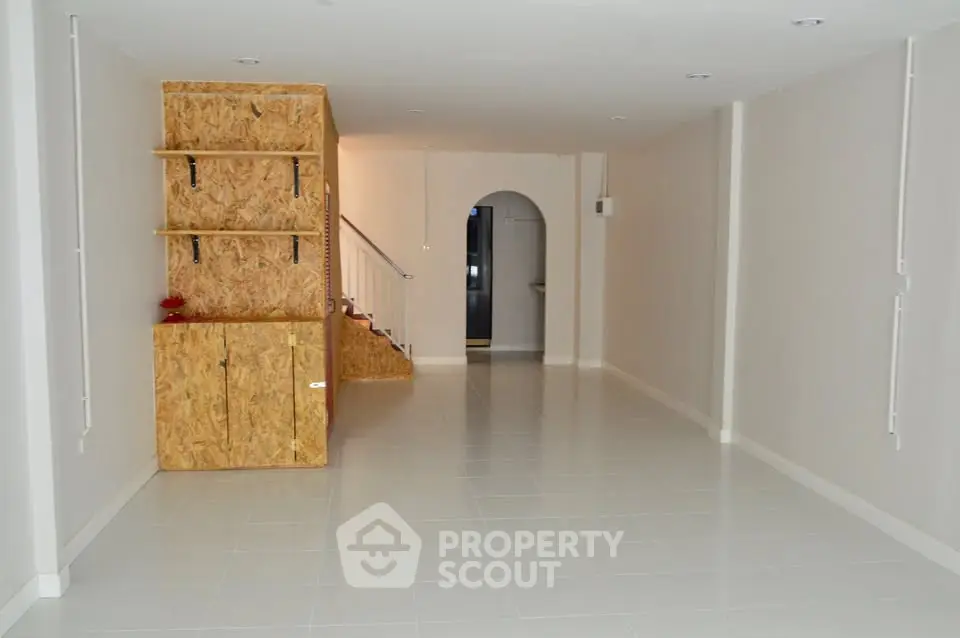 Spacious modern interior with minimalist design and unique wooden shelving unit.