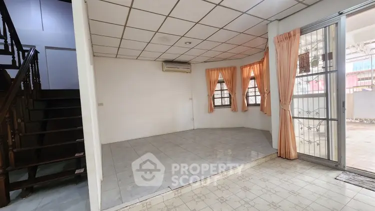 Spacious living room with tiled floor and large windows in a cozy home