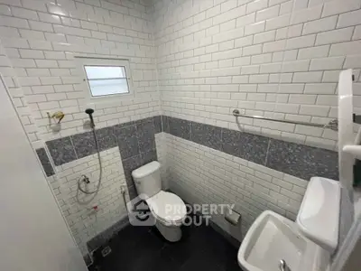 Modern bathroom with white subway tiles and compact fixtures.