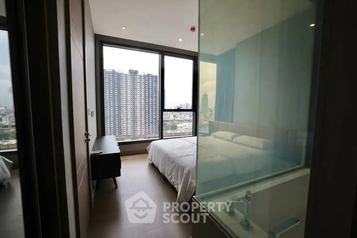 Modern bedroom with city view and glass partitioned bathroom