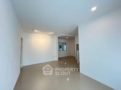 Spacious empty living room with glossy tiled floors and bright lighting