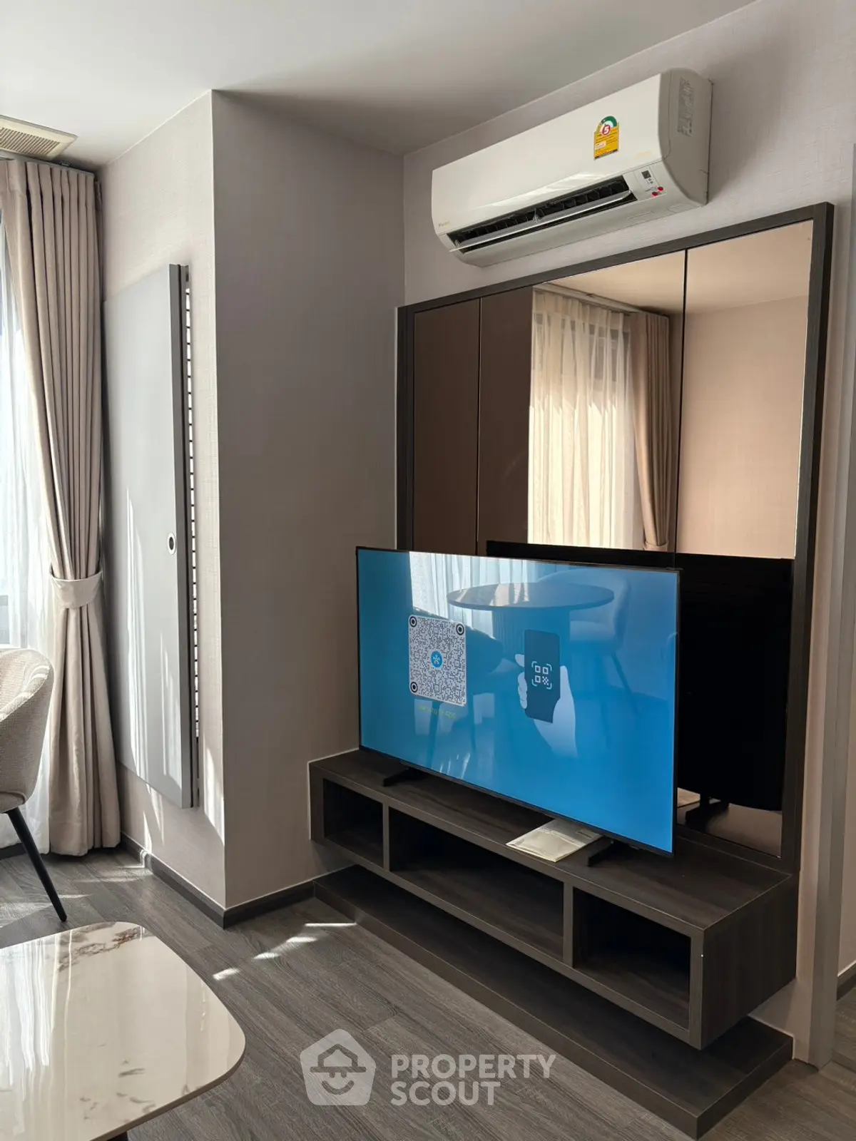 Modern living room with sleek TV setup and air conditioning