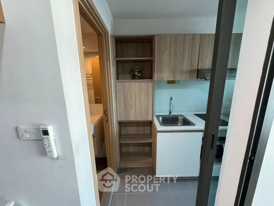 Modern compact kitchen with sleek cabinetry and integrated appliances in a stylish apartment.