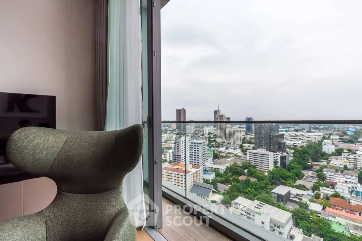 Stunning city view from modern high-rise apartment balcony with sleek glass railing.