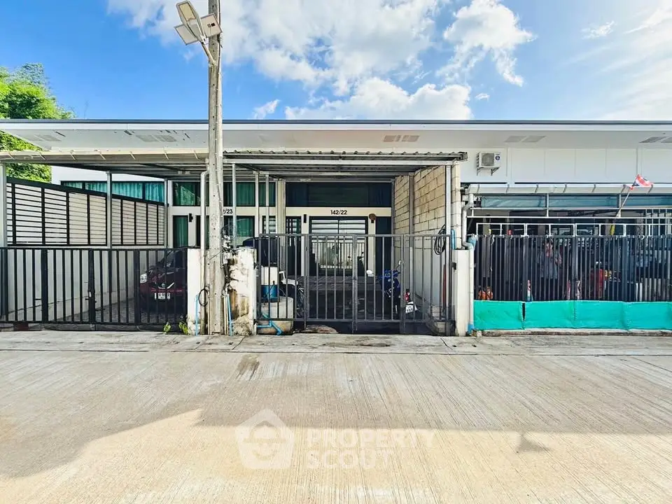 Modern single-story house with gated entrance and driveway, featuring a sleek design and ample outdoor space.