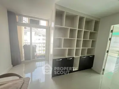 Modern living room with built-in shelving and balcony access