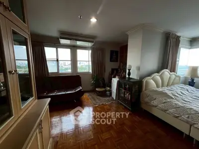 Spacious bedroom with city view, parquet flooring, and elegant decor for a cozy urban retreat.