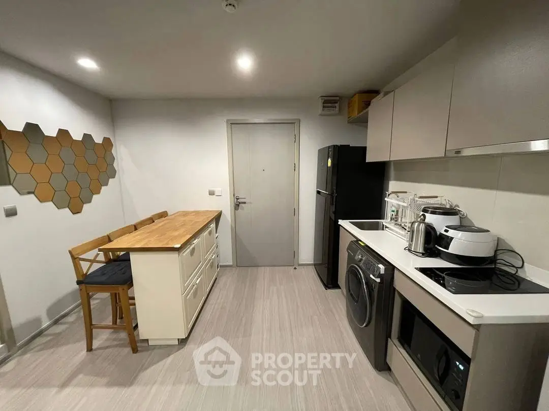 Modern kitchen with sleek appliances and stylish decor in a contemporary apartment.