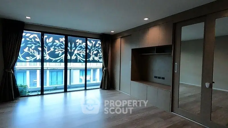 Spacious modern living room with large windows and elegant wooden flooring