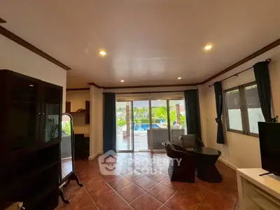 Spacious living room with pool view and elegant tile flooring