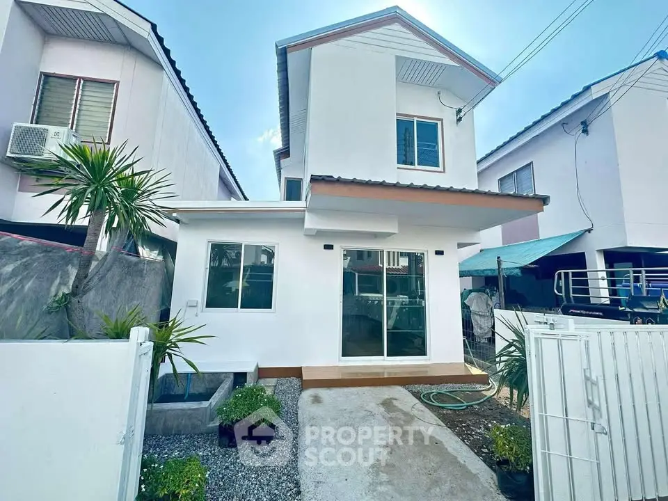 Charming two-story white house with modern design and small garden in a serene neighborhood.