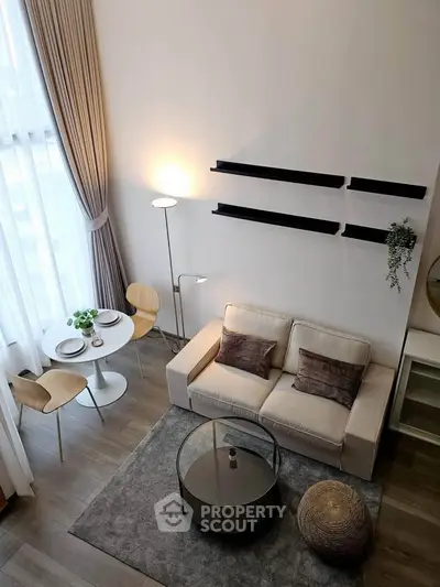 Modern living room with high ceiling, cozy sofa, and elegant dining area in a stylish apartment.