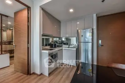 Modern kitchen with sleek cabinetry and stainless steel appliances in a stylish apartment.