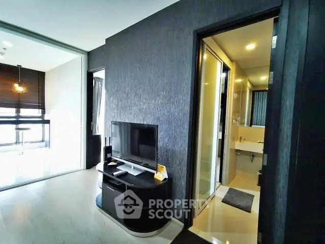 Modern apartment interior with sleek living room and adjacent bathroom, featuring contemporary design and natural light.