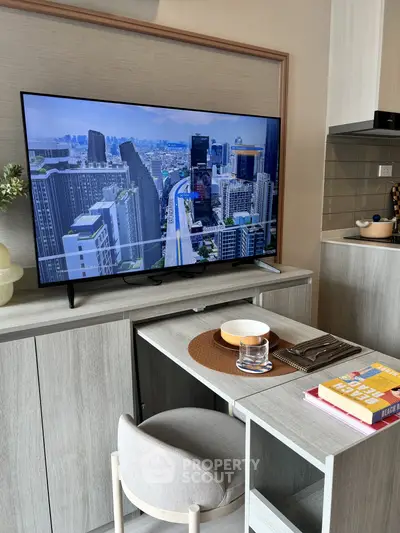 Modern living room with sleek TV setup and stylish dining area in a contemporary apartment.