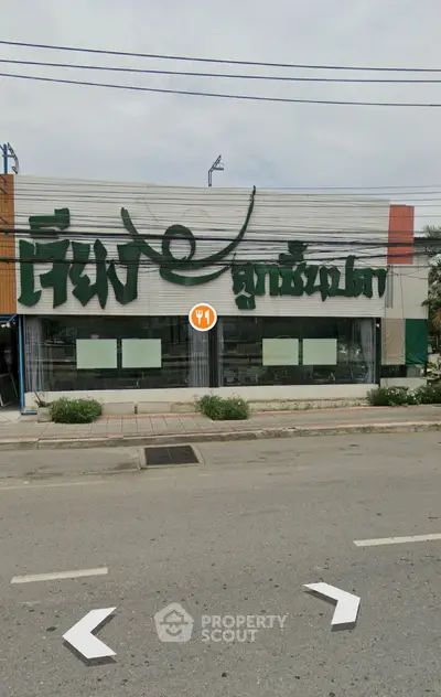 Street view of commercial building with large signage and glass windows