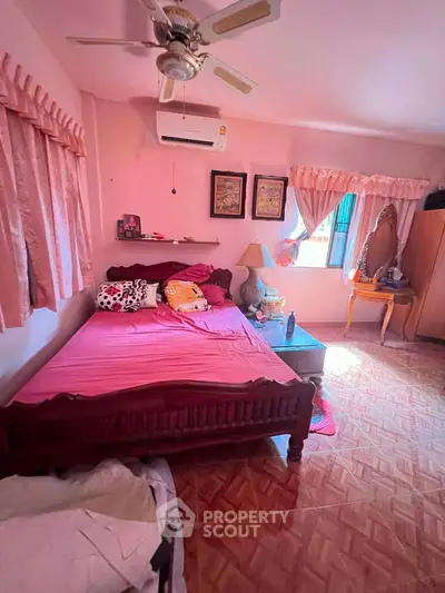 Charming bedroom with pink decor, wooden bed, and natural light, perfect for cozy living.