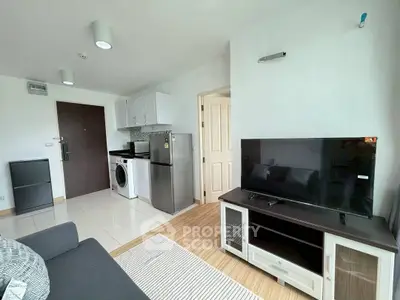 Modern living room with compact kitchen and sleek appliances in a cozy apartment.