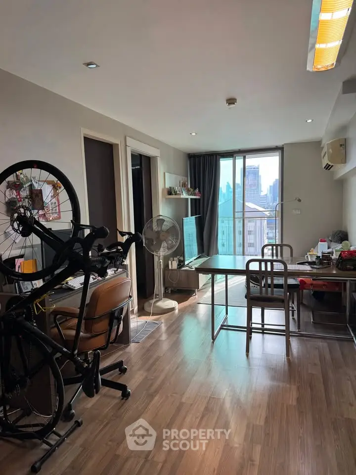 Modern living room with city view and open layout, featuring stylish furniture and natural light.