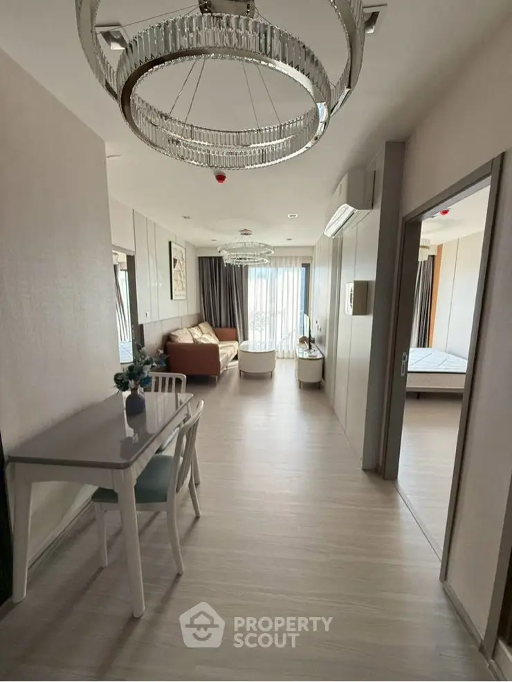 Modern apartment interior with elegant lighting and open layout, featuring a cozy living area and dining space.