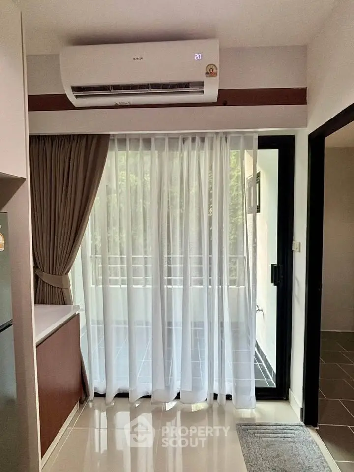 Modern apartment interior with balcony view and air conditioning, featuring sleek design and natural light.