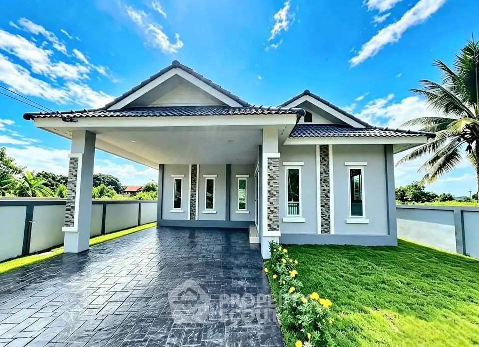 Stunning modern house with spacious driveway and lush green lawn under a clear blue sky.