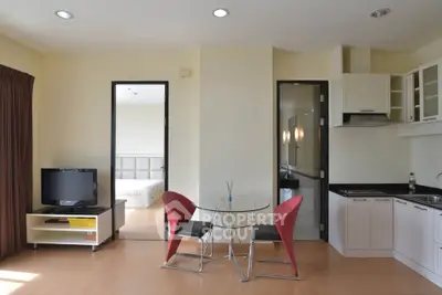 Modern open-plan living room with kitchen and dining area in a cozy apartment.