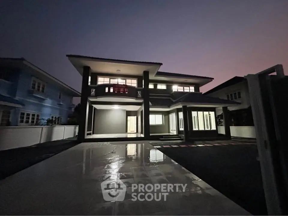 Stunning two-story modern home with spacious driveway and elegant exterior lighting.