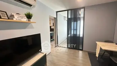 Modern apartment interior with sleek design and glass partition, featuring a cozy living area and stylish decor.