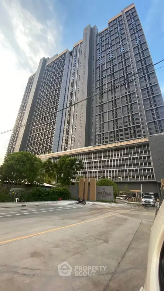 Modern high-rise building with sleek design and spacious surroundings.