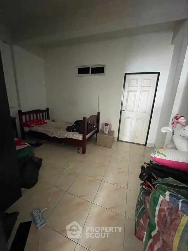 Cozy bedroom with single bed and tiled flooring, ideal for minimalist living.