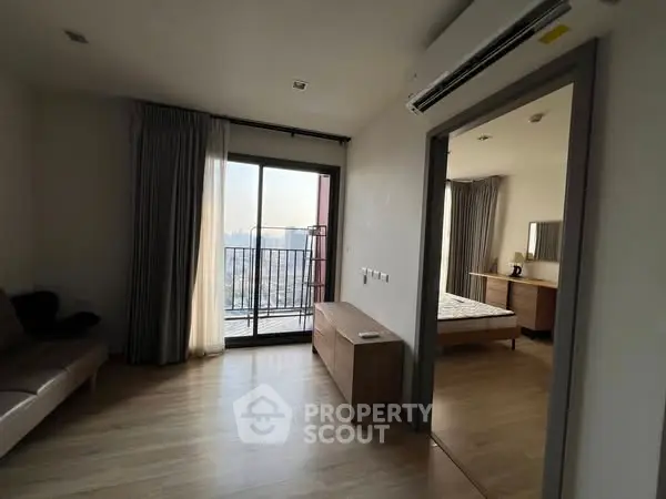 Modern apartment with balcony and bedroom view, featuring sleek design and natural light.