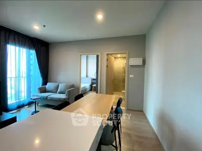 Modern living room with dining area and large windows in a stylish apartment.