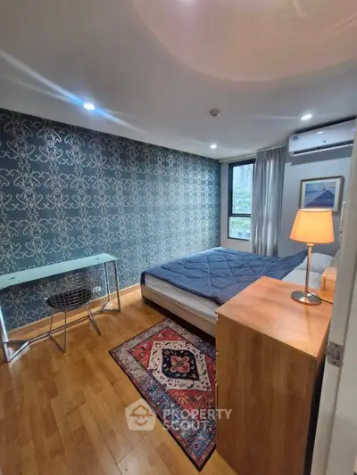 Modern bedroom with stylish wallpaper, wooden flooring, and cozy lighting in a contemporary apartment.