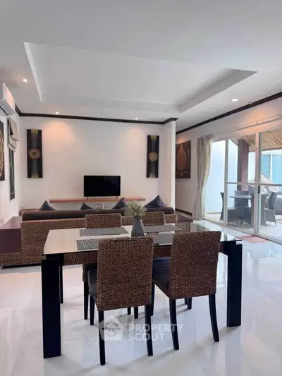 Spacious modern living room with dining area and large balcony access, perfect for entertaining.