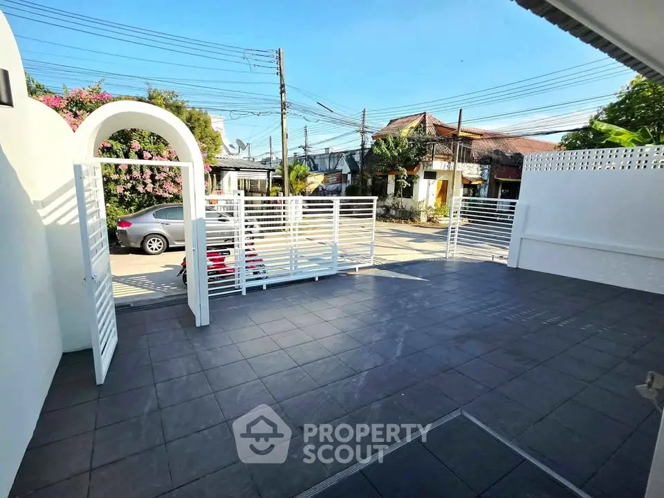 Spacious outdoor patio with modern white fencing and tiled flooring