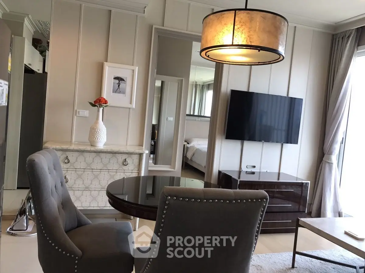 Elegant living room with modern decor and stylish furniture, featuring a wall-mounted TV and chic lighting.